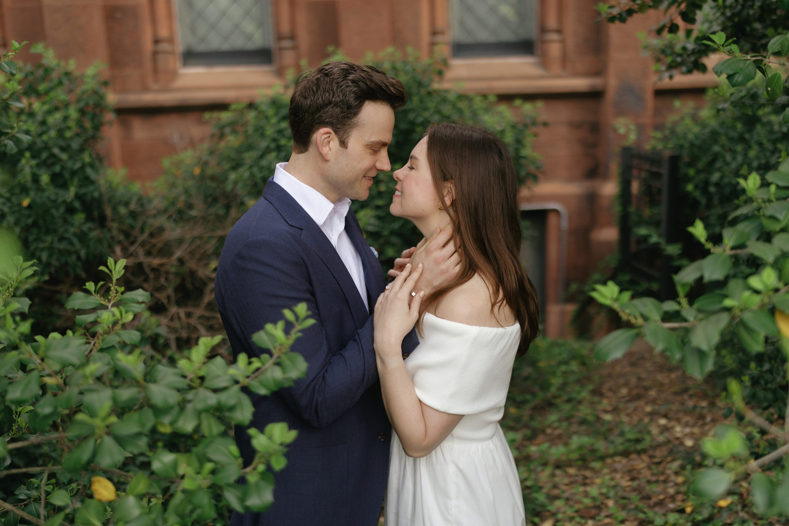 Close portrait of a couple laughing together, her hand on his face, during their DC engagement session